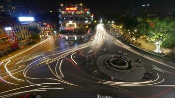 City square with traffic in motion at night. Hanoi, Vietnam photo