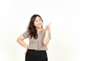 mostrando el producto y apuntando hacia el lado usando el dedo índice de una hermosa mujer asiática aislada en blanco foto