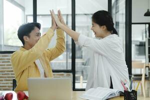 Motivated multinational team raise high fives on briefing after finding problem solution as successful brainstorm result. photo