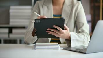 bedrijf vrouw werken met digitaal tablet computer en slim telefoon met financieel bedrijf strategie laag effect Aan bureau video