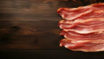 Slices of bacon on wooden table, top view. Space for text photo