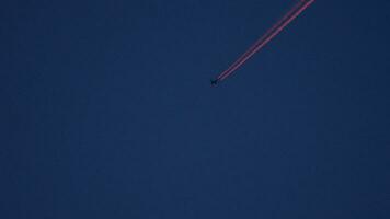 Hermoso sendero de avión de 4k en la luz roja del atardecer en el cielo azul, contaminación de la capa de aviones video