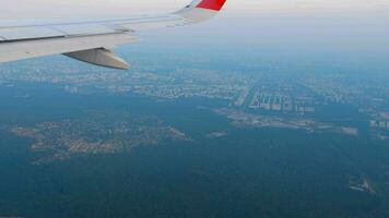 Flight, descent for landing, view from the porthole. Top view of the city. Flight, tourism and travel concept video