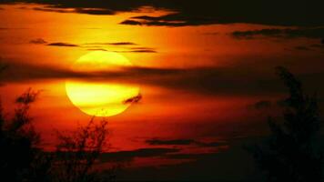 runden rot Sonne und dunkel Wolken, malerisch Sonnenuntergang. natürlich Hintergrund, Abend Dämmerung video