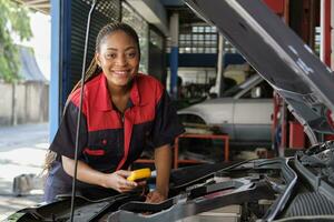 One Black female professional automotive mechanical worker checks an EV car battery and hybrid engine at a maintenance garage, expert electric vehicle service, and fixing occupations auto industry. photo