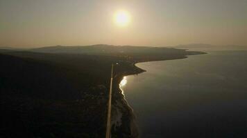 antenn scen av strandlinje, hav och grön höglänt på solnedgång, grekland video