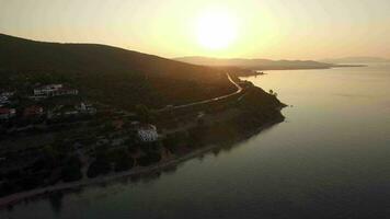 Flying over sea and Trikorfo Beach coastline at sunset, Greece video