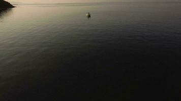 aéreo Visão do esvaziar barco dentro quieto mar às pôr do sol video