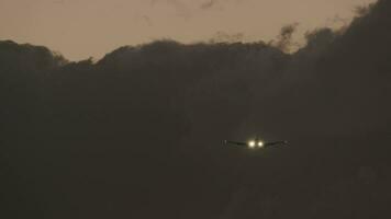 Flugzeug mit Scheinwerfer aufsteigend gegen schwer Wolken im Abend Himmel video