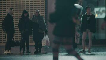 People crossing the street in wet evening video