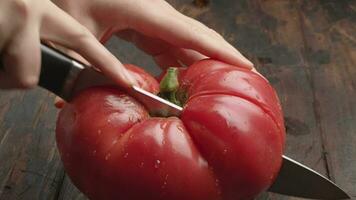 Cutting big ripe tomato in half video