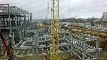 A vertical inspection of a construction crane against the building frame and a busy highway video