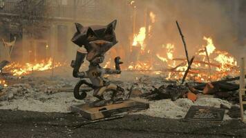 The satirical cat figure against the dying bonfire after the Falles night video