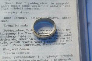 pequeño redondo anillo acostado en el texto de el matrimonio voto de el cristiano religión en polaco palabras foto