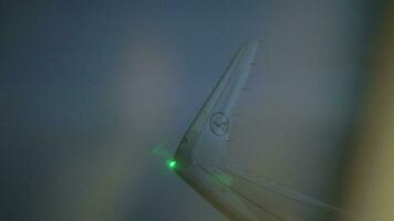 Looking through illuminator to plane wing with lights blinking video