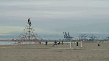 kinderen spelen Aan strand en beklimming touw netto kust visie met kranen, Valencia video