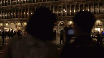 San Marco Square at night and tourists taking pictures with cells Venice, Italy video