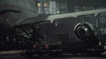 Boeing 747-400 of Thai Airlines is prepared for unloading baggage at night video