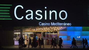 People walking in the street with gambling house at night Alicante, Spain video