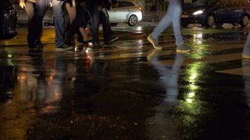 pessoas em pedestre faixa de pedestre às chuvoso noite dentro cidade Paris, França video