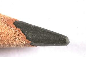 close-up on a rough wooden pencil on a white isolated background photo