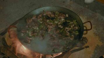 sissend kip en knoflook in een paella pan video