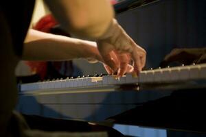 de cerca en el manos de un mujer jugando el piano con música llaves foto