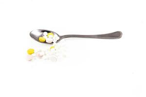 silver spoon with medicine lying on a white isolated background photo