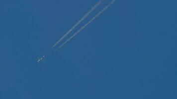 Aircraft contrail against clear blue sky. Airplane flying high video