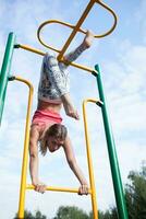 Beautiful young gymnast working out outdoors photo