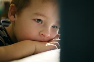 Boy watching cartoons on touchpad photo