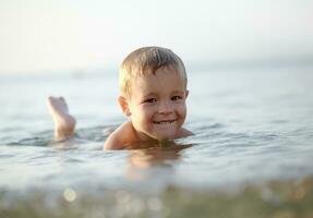 Smiling little boy in the sea photo