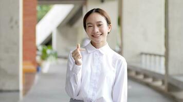 Smiling Asian woman showing working heart gesture video