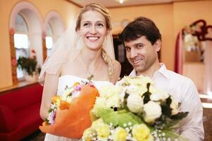 Smiling bride and groom with bouquets of flowers photo