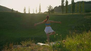 yoga rutina de ejercicio de hembra atleta. joven sano mujer haciendo yoga en el montañas durante amanecer. bienestar y sano estilo de vida, zen concepto. lento movimiento. video