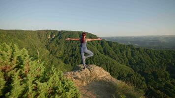 Yoga trainieren von weiblich Athlet. jung gesund Frau tun Yoga im das Berge während Sonnenaufgang. Wohlbefinden und gesund Lebensstil, Zen Konzept. schleppend Bewegung. video