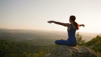 yoga rutina de ejercicio de hembra atleta. joven sano mujer haciendo yoga en el montañas durante amanecer. bienestar y sano estilo de vida, zen concepto. lento movimiento. video