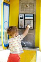 Young boy talking to the phone in a booth photo