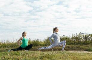 Two young girls exercising outdoors photo