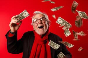 senior man and flying money on studio red background. photo