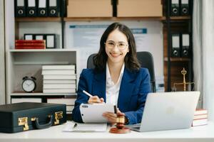 Beautiful woman lawyer working and gavel, tablet, laptop in front, Advice justice and law concept. photo