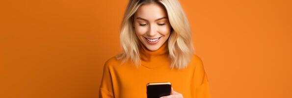 girl with phone on orange background. photo