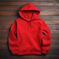 Blank red hoodie lying on the table, photographed from above photo