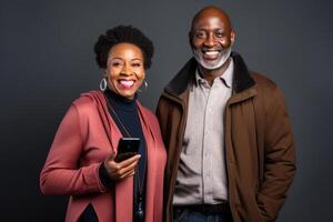 attractive mature black woman and black man with phone on studio color background. photo