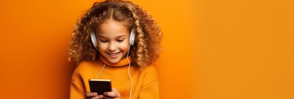 girl with phone on orange background. photo
