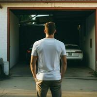 ai generativo un hombre vistiendo un llanura blanco t - camisa en el garaje frente a hacia atrás, Perfecto a crear camiseta Bosquejo foto