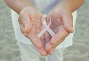 Hands holding pink ribbon photo