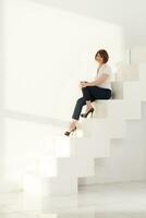Elegant adult woman smiling while sitting on steps photo