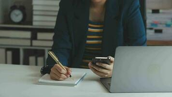 close-up mulher de negócios usando calculadora e laptop para fazer finanças matemáticas na mesa de madeira, impostos, contabilidade, estatística e conceito de pesquisa analítica video