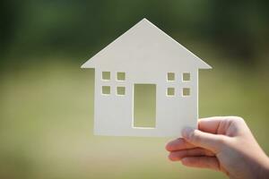 Hand holding house model outdoor photo